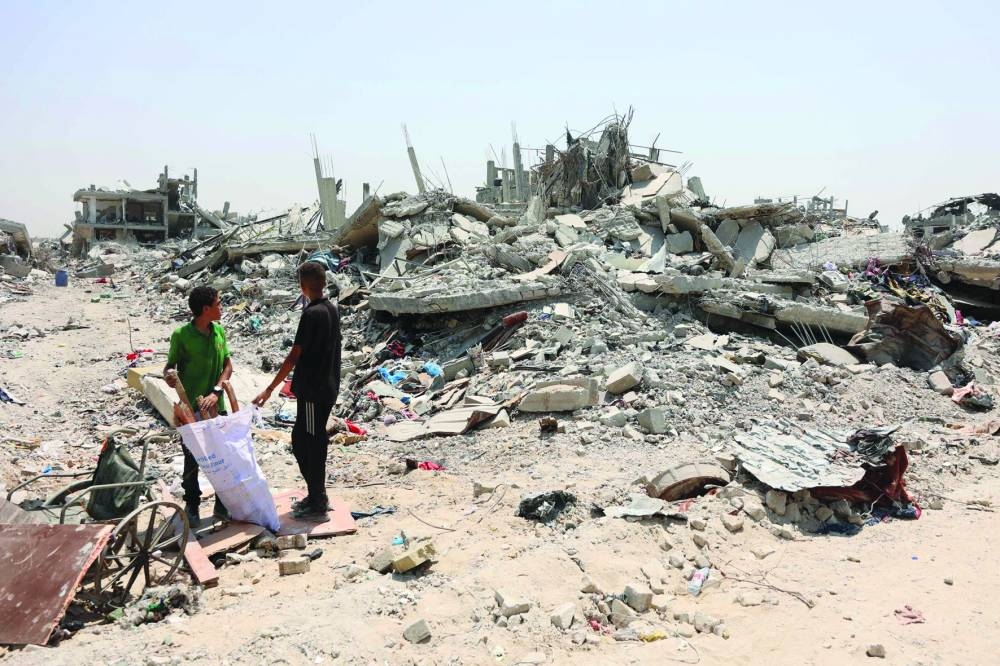 
Palestinian boys search for wood, to salvage to use as firewood, next to destroyed buildings in the Al-Tuffah neighbourhood of Gaza City, following more than 22 months of Israeli war on Gaza. 