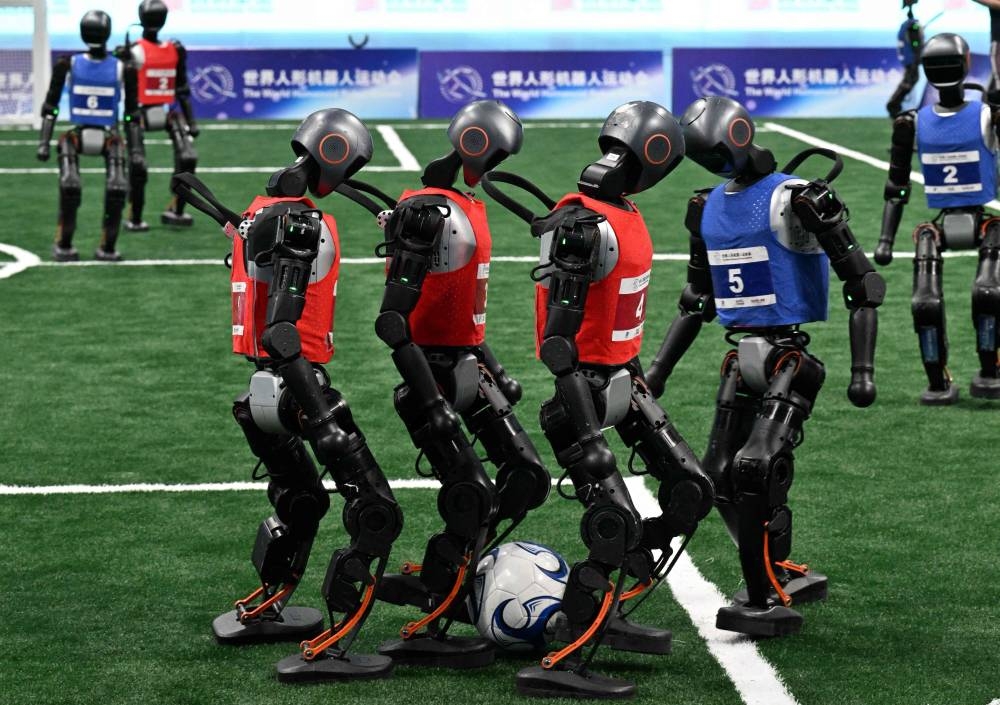 Robots compete in a 5x5 football match during the World Humanoid robots games in Beijing on August 16, 2025. (AFP)