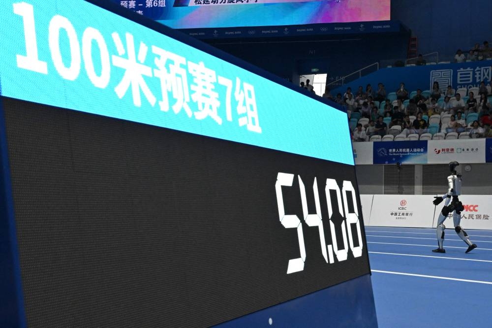 A robot competes in the 100M run during the World Humanoid robots games in Beijing on August 16, 2025. (AFP)