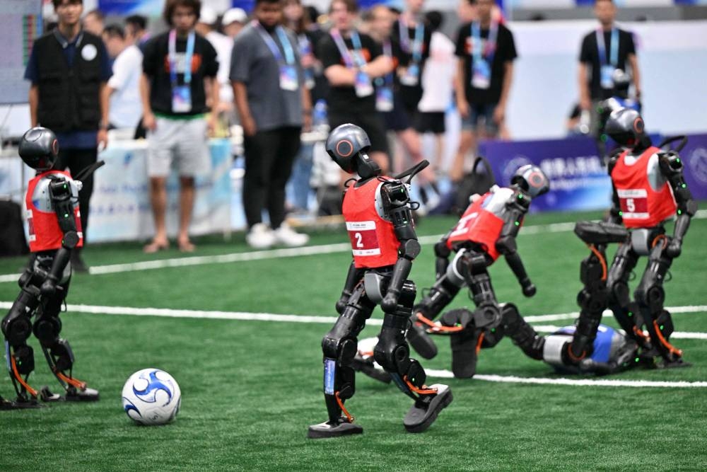 Robots compete in a 5x5 football match during the World Humanoid robots games in Beijing on August 16, 2025. (AFP)