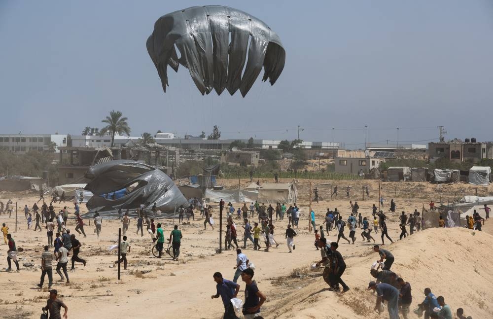 Aid packages, dropped from an airplane, descend over Gaza, in Deir Al-Balah, in the central Gaza Strip August 19, 2025. (REUTERS)