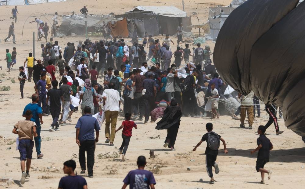 Palestinians run towards airdropped aid packages, in Deir Al-Balah, in the central Gaza Strip August 19, 2025. (REUTERS)