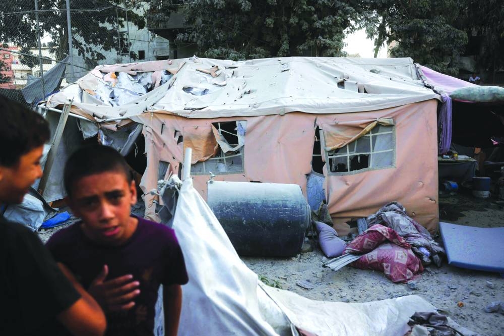 Palestinian youths gather near a damaged displacement tent following an Israeli strike on a six-storey building in the Saftawi neighborhood west of Jabalia in the northern Gaza Strip Tuesday.