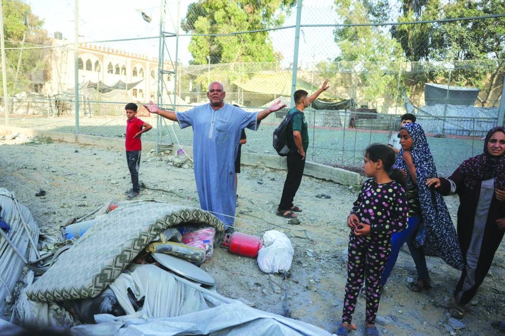 A Palestinian man reacts after his displacement tent was damaged at the site of Israeli air strikes on a six-storey building in the Saftawi neighbourhood west of Jabalia in the northern Gaza Strip Tuesday.