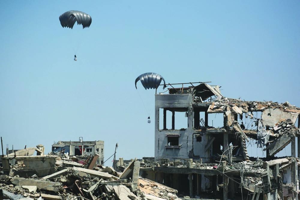 Aid pallets are parachuted after being dropped from a military plane near Jabalia in the northern Gaza Strip, Wednesday.