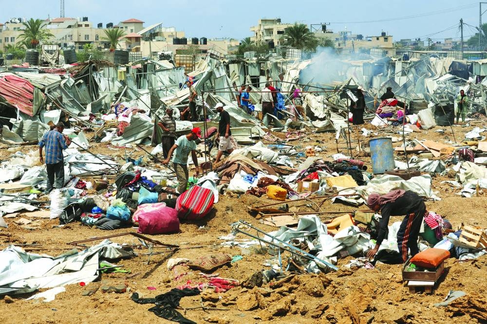 Palestinians inspect the damage at the site of an Israeli strike on a tent camp sheltering displaced people, in Deir Al-Balah, in the central Gaza Strip, Thursday. (Reuters)