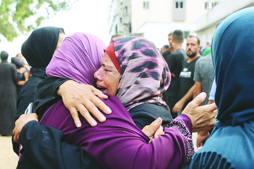 Palestinians mourn relatives killed in Israeli strikes ahead of their funeral at Al-Shifa hospital in Gaza City. (AFP)