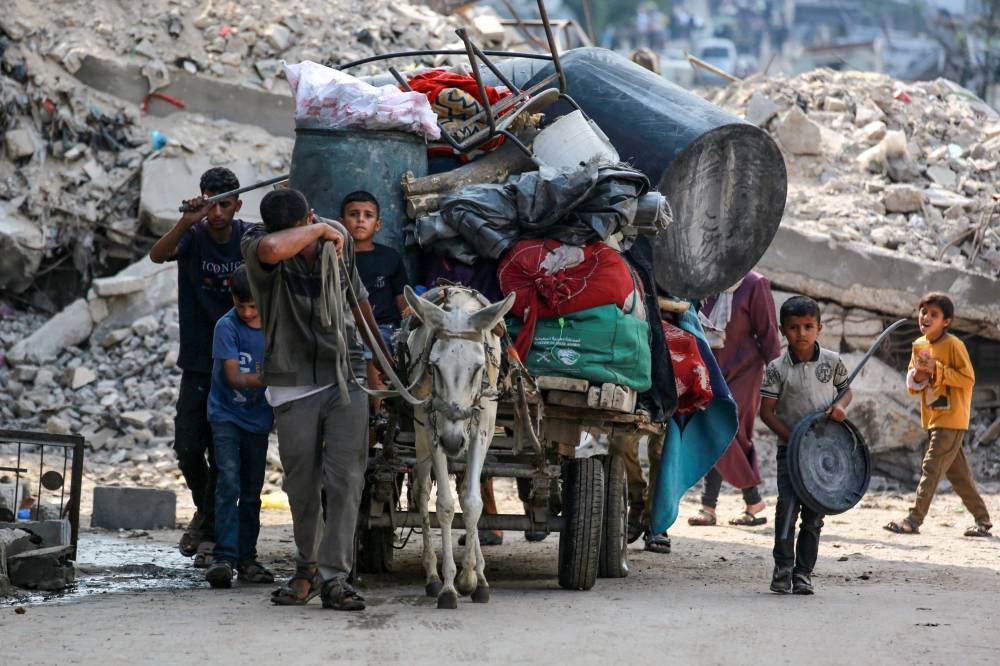 Palestinians transport their belongings on a donkey-pulled cart as they flee the Abu Iskandar neighborhood of northern Gaza City on August 22, 2025. (AFP)