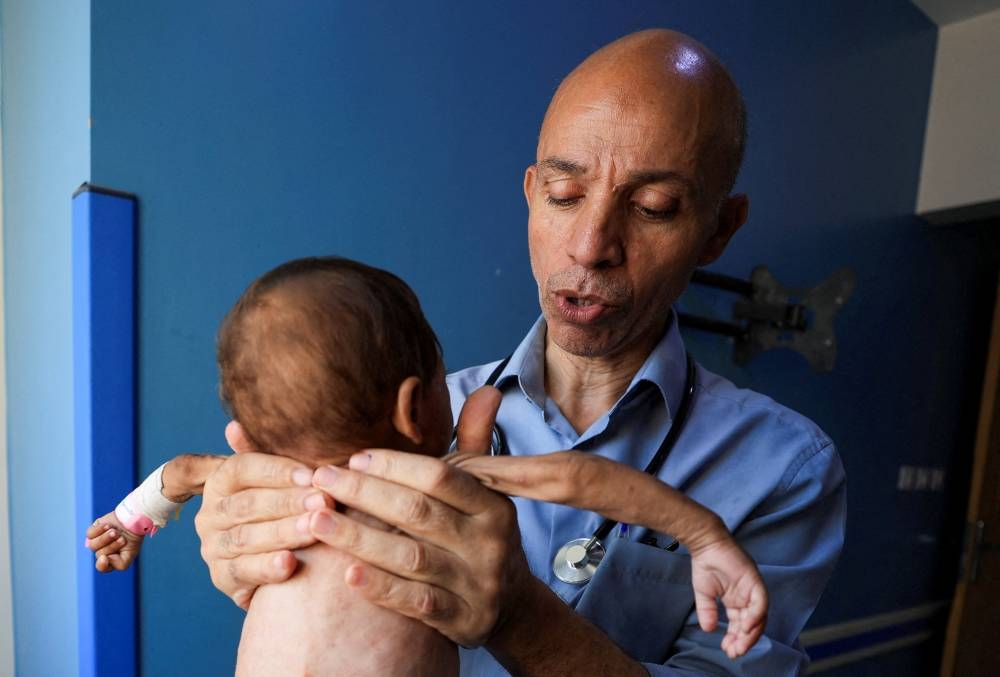 Palestinian doctor Ahmed Basal examines a child for malnutrition at Al-Rantisi Hospital in Gaza City, August 7. REUTERS