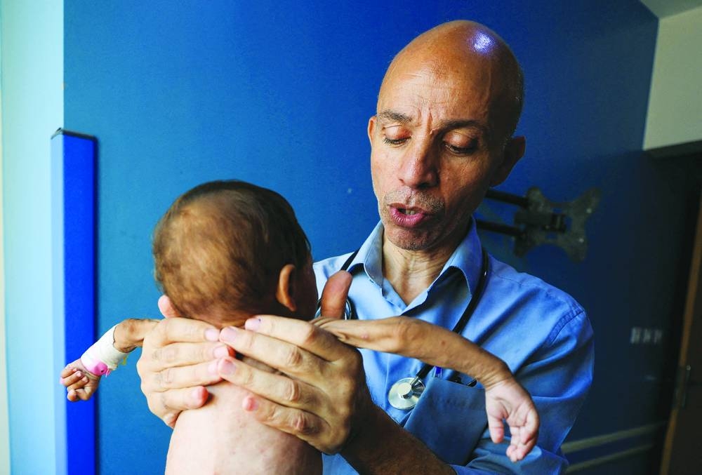 
Palestinian doctor Ahmed Basal examines a child for malnutrition at Al-Rantisi Hospital in Gaza City. 