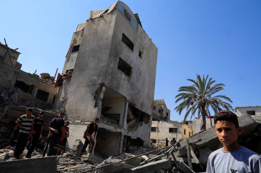 Palestinians inspect the site of an Israeli strike on a house in Deir Al-Balah, in the central Gaza Strip August 23, 2025. REUTERS