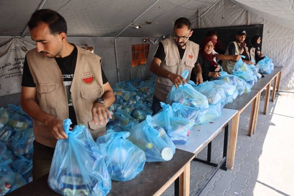 Volunteers with the Gaza Soup Kitchen prepare food rations to distribute to displaced Palestinians in the Sheikh Radwan neighbourhood of Gaza City on Sunday. AFP