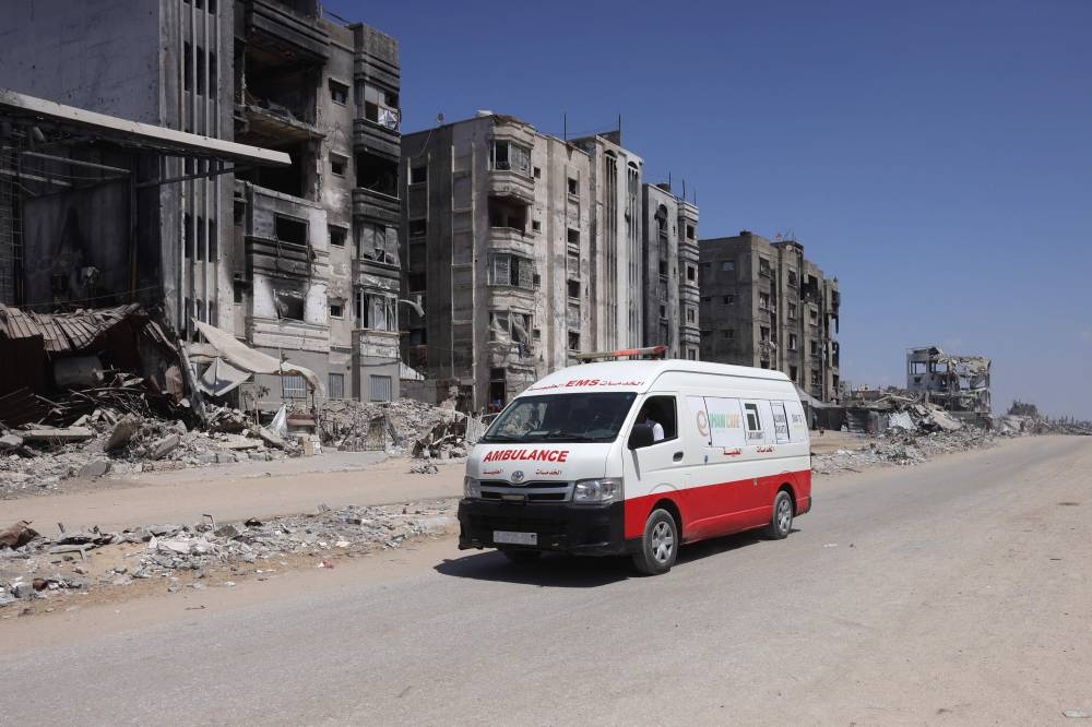 An ambulance drives past destroyed buildings in Jabalia's Saftawy neighbourhood on August 26, 2025. Israel's defence minister on June 20, approved a military plan for the conquest of Gaza City, authorising the call-up of about 60,000 reservists, piling pressure on Hamas as mediators push for a ceasefire. (Photo by BASHAR TALEB / AFP)