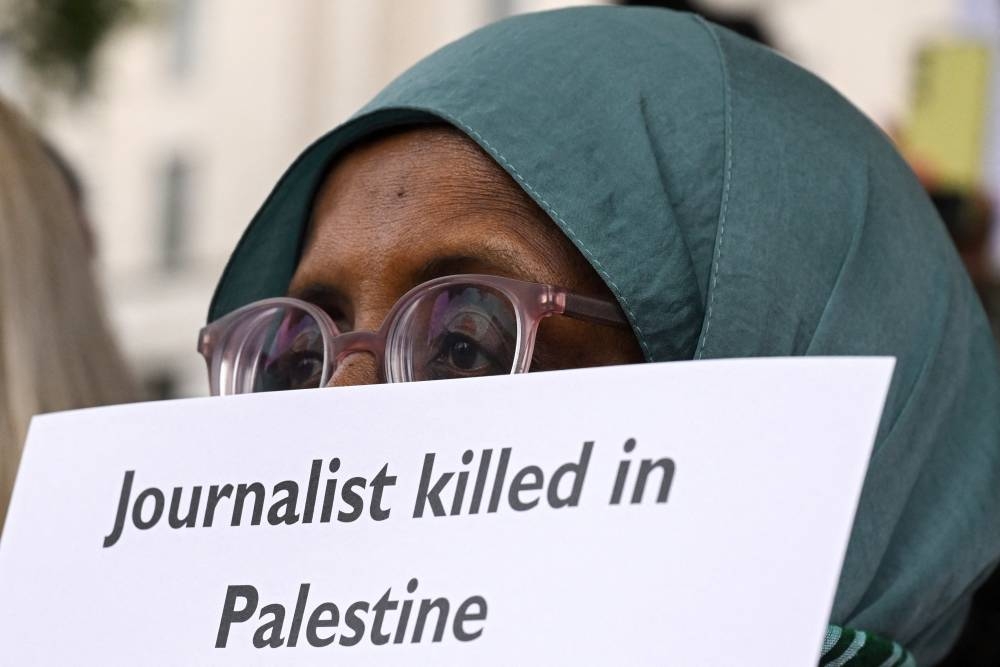 A woman holds a placard during a vigil outside 10 Downing Street, organised by the National Union of Journalists London Freelance Branch, to remember the nearly 200 journalists killed in Gaza since October 2023, according to the Committee to Protect Journalists, in London, Britain August 27, 2025. REUTERS