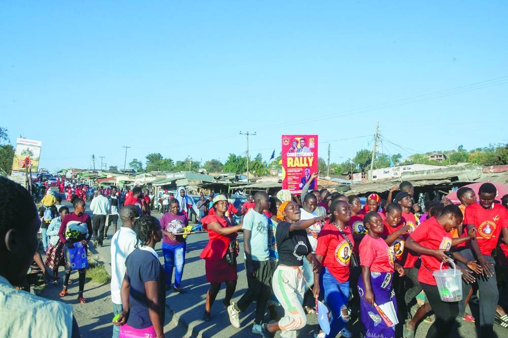 Supporters of UTM Parliamentary candidate Fredo Penjani Kalua, also known as Fredokiss, sing as they walk to a campaign rally in Blantyre.