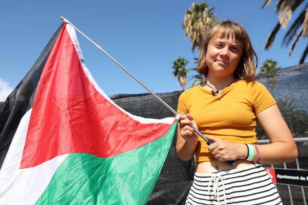 Swedish climate activist Greta Thunberg poses with a Palestinian flag as a flotilla carrying humanitarian aid and activists prepare to leave for Gaza, in Barcelona, Saturday.