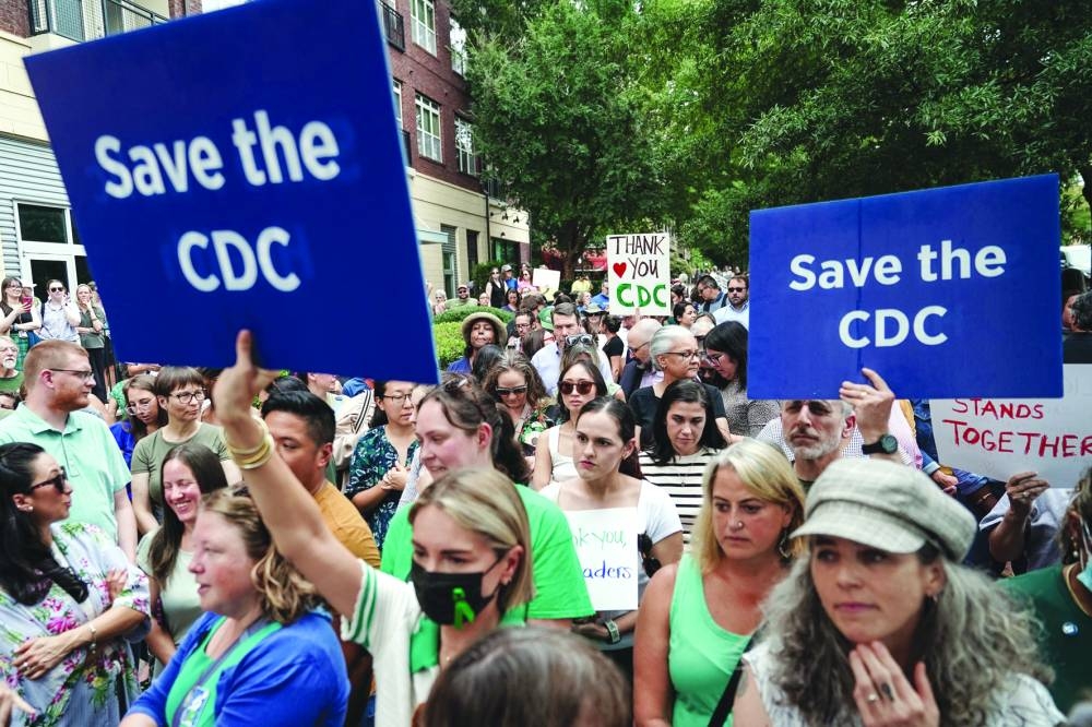 This picture taken on Thursday shows employees and supporters of the CDC holding signs and clapping and cheering to honour former officials, outside its global headquarters in Atlanta, Georgia.  (AFP)