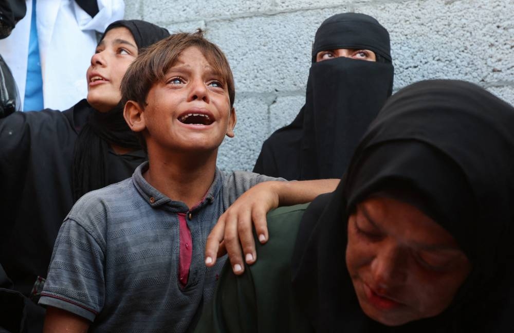 Mourners react during the funeral of Palestinians killed by Israeli fire while trying to receive aid on Sunday, according to medics, at Nasser Hospital in Khan Younis, southern Gaza Strip, on Monday. REUTERS