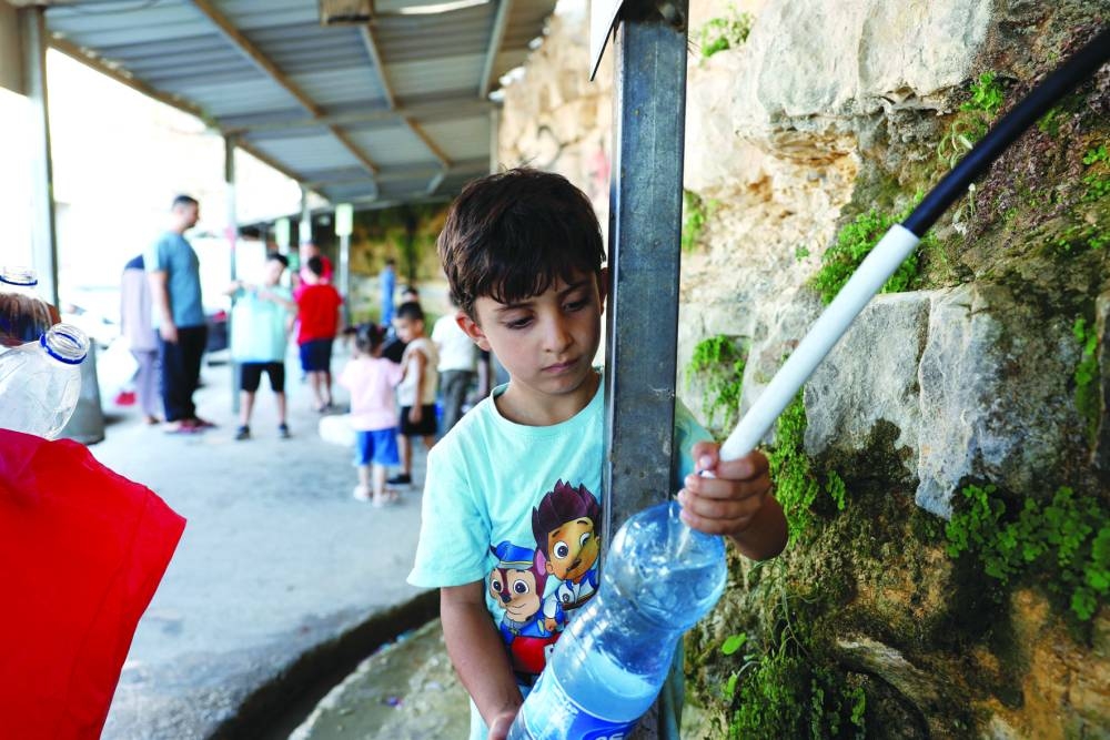 A Palestinian boy fills a water bottle from a public water point, in Ramallah in the occupied West Bank.