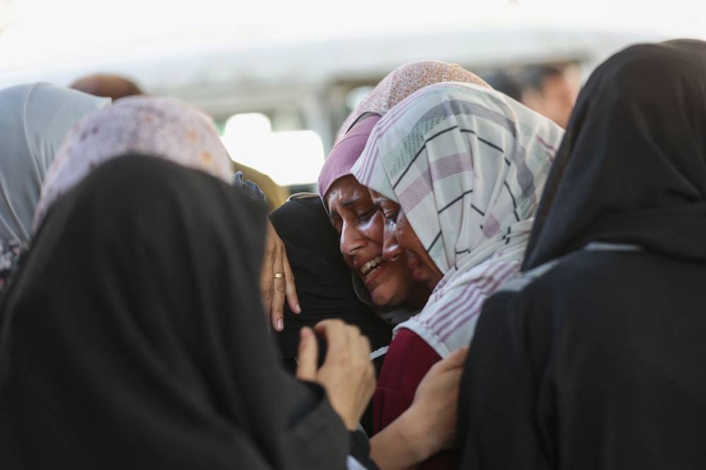 Palestinian women commiserate outside the Al-Shifa hospital where casualties of Israeli strikes on Gaza City at dawn were brought on Tuesday. AFP