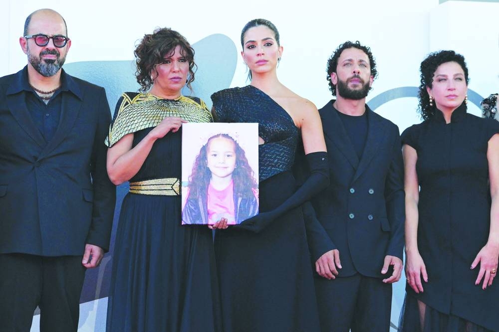 From left: Actor Amer Hlehel, Tunisian director Kaouther Ben Hania, actress Saja Kilani, actor Motaz Malhees, actress Clara Khoury pose with a portrait of late Palestinian girl Hind Rajab, during the red carpet for the movie "The Voice of Hind Rajab" presented in competition at the 82nd International Venice Film Festival, at Venice Lido, Wednesday.