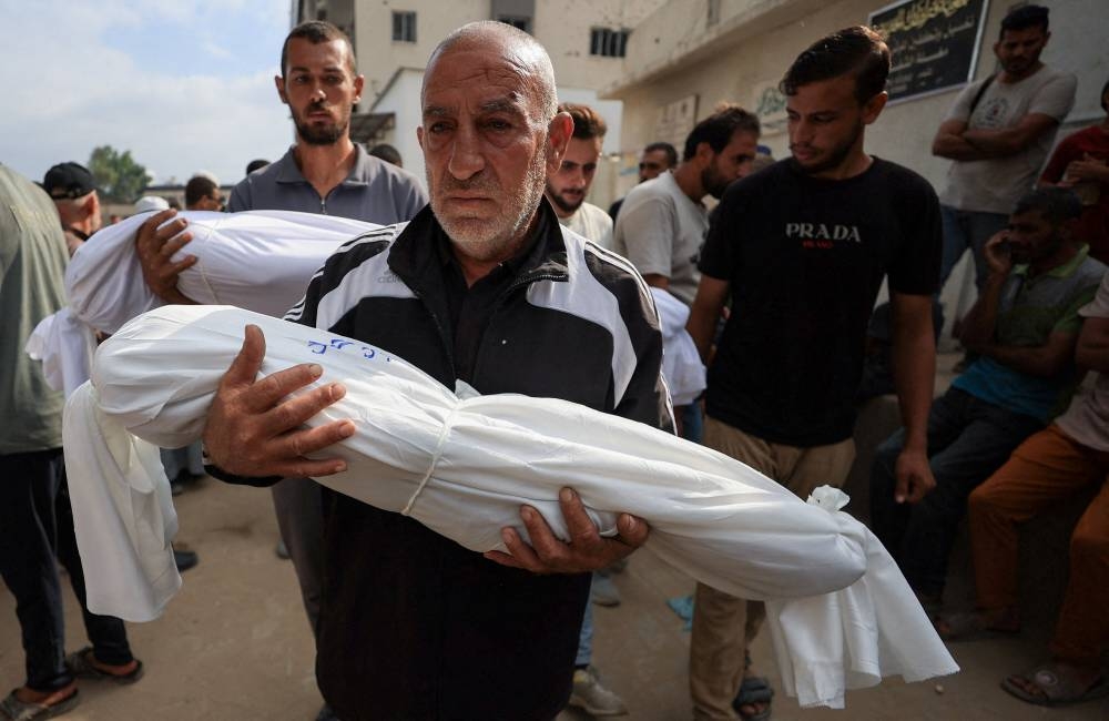Mourners carry the covered bodies of children during the funeral of Palestinians who were killed by Israeli fire while trying to receive aid on Wednesday and others who were killed in overnight strikes, according to medics, at Al-Shifa Hospital in Gaza City, September 4, 2025. REUTERS