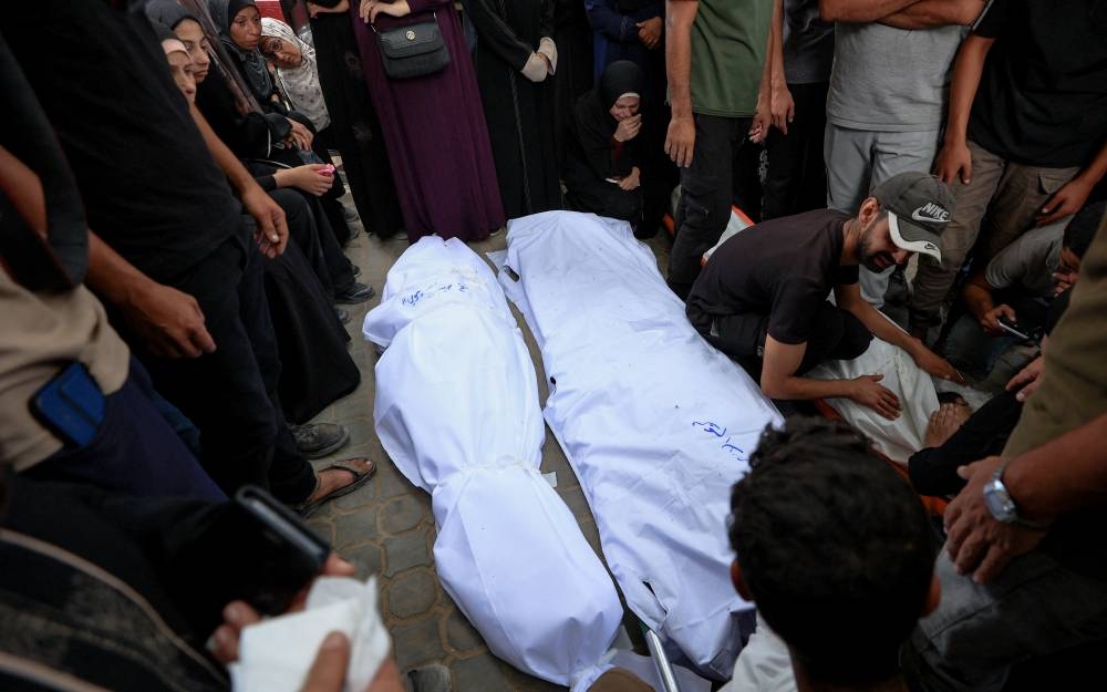 Mourners gather next to covered bodies during the funeral of Palestinians who were killed by Israeli fire while trying to receive aid on Wednesday and others who were killed in overnight strikes, according to medics, at Al-Shifa Hospital in Gaza City, September 4, 2025. REUTERS