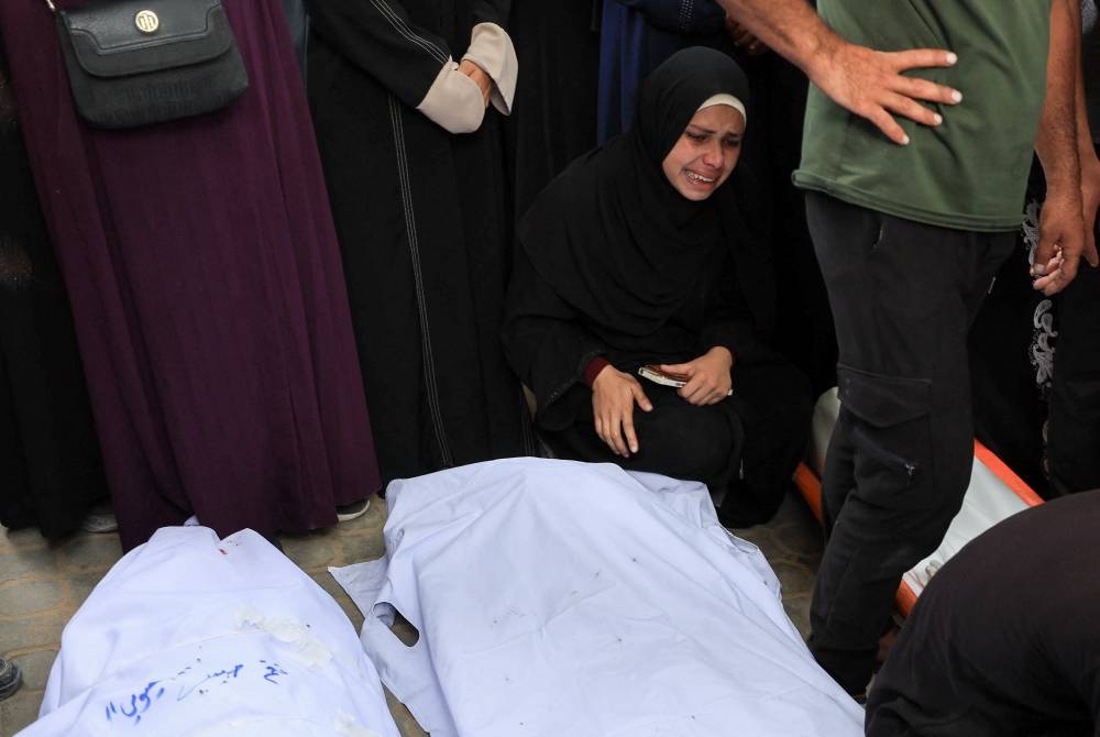 A mourner reacts next to covered bodies during the funeral of Palestinians who were killed by Israeli fire while trying to receive aid on Wednesday and others who were killed in overnight strikes, according to medics, at Al-Shifa Hospital in Gaza City, September 4, 2025. REUTERS