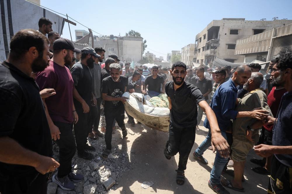 Palestinians carry the body of a man killed in an Israeli strike on a tent, according to medics, outside Al-Shifa Hospital in Gaza City, September 4, 2025. REUTERS