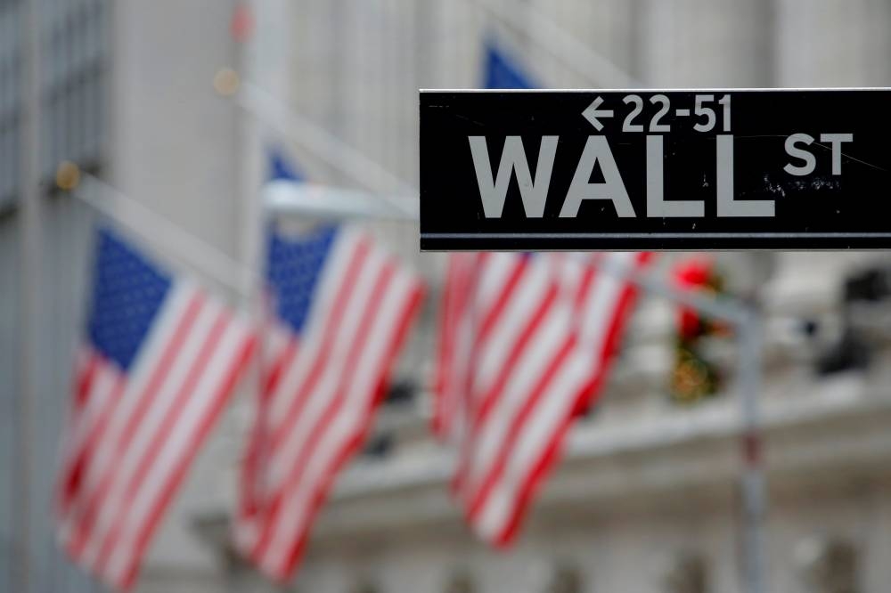 A street sign for Wall Street is seen outside the New York Stock Exchange. Moody’s Ratings stripped the US of its last-remaining top credit score in May, citing fears that the ballooning national debt and deficit will damage the country’s standing as the preeminent destination for global capital.