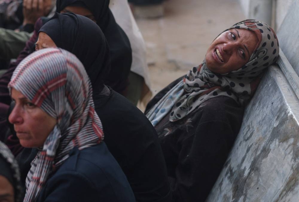 A woman reacts as mourners gather around the bodies of Palestinians killed in overnight Israeli strikes, according to medics, during their funeral at Al-Shifa Hospital in Gaza City, September 5, 2025. REUTERS