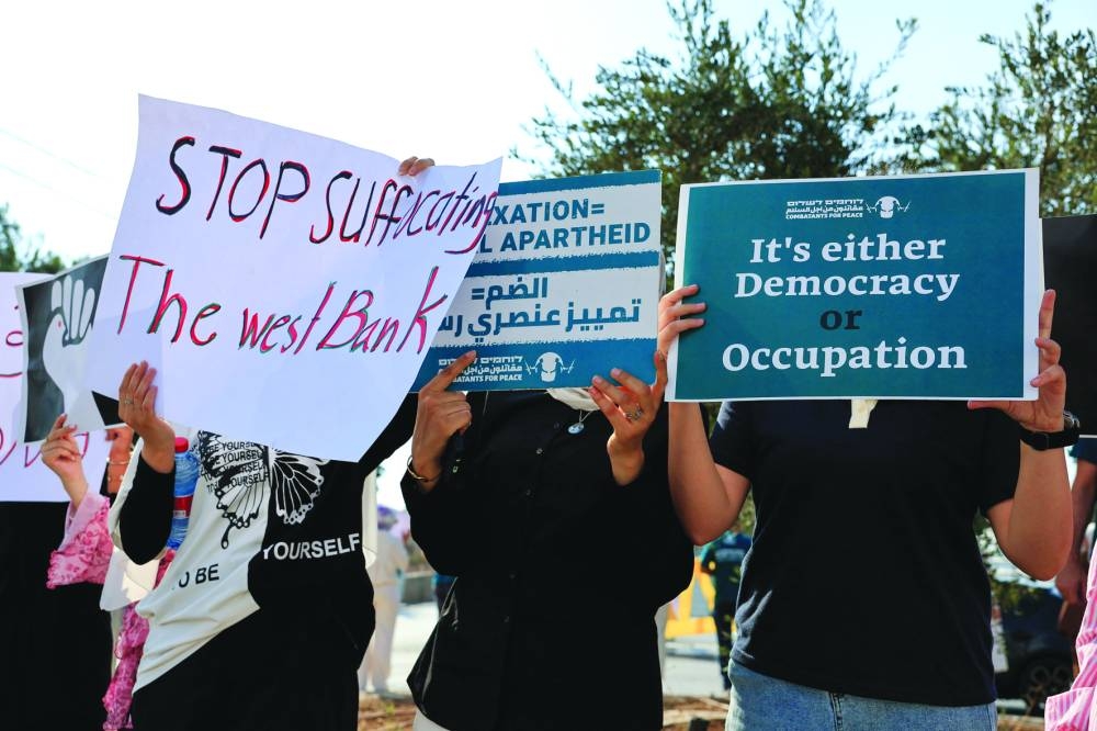 Demonstrators display placards during a protest by Palestinian and Israeli activists against starvation in Gaza, near Beit Jala in the occupied West Bank, Friday.