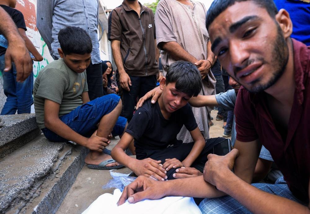 A child reacts during the funeral of Palestinians killed by Israeli fire while trying to receive aid on Friday, and others killed in overnight strikes, according to medics, at Al-Shifa Hospital in Gaza City, REUTERS