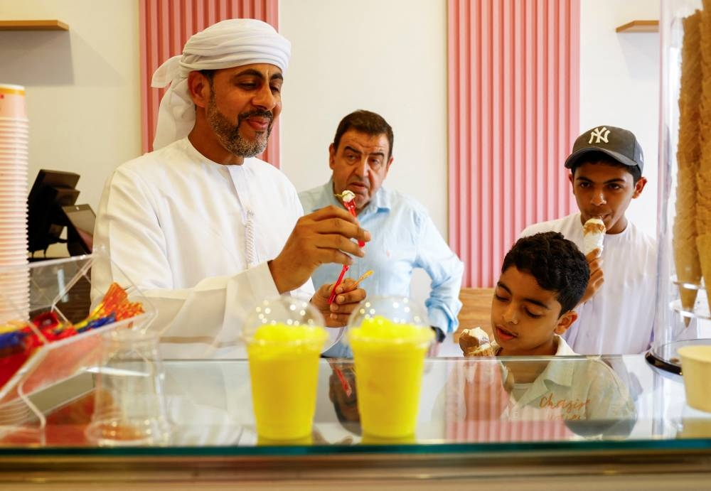 A traditional Palestinian "Barrad", a slushy drink with citrus flavours, is displayed as customers enjoy ice cream at a newly opened branch of an ice cream shop that was partially destroyed in Gaza during the ongoing conflict between Israel and Hamas, in Ajman, United Arab Emirates.