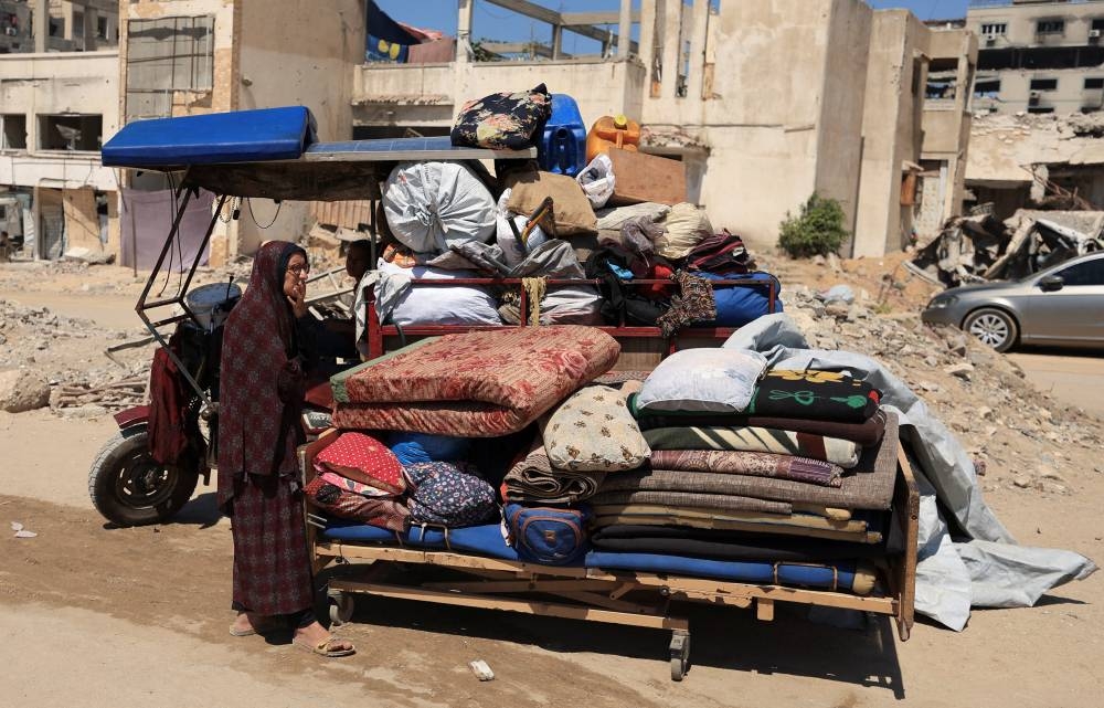 A displaced Palestinian stands next to packed belongings amid an Israeli military operation, in Gaza City, yesterday.
