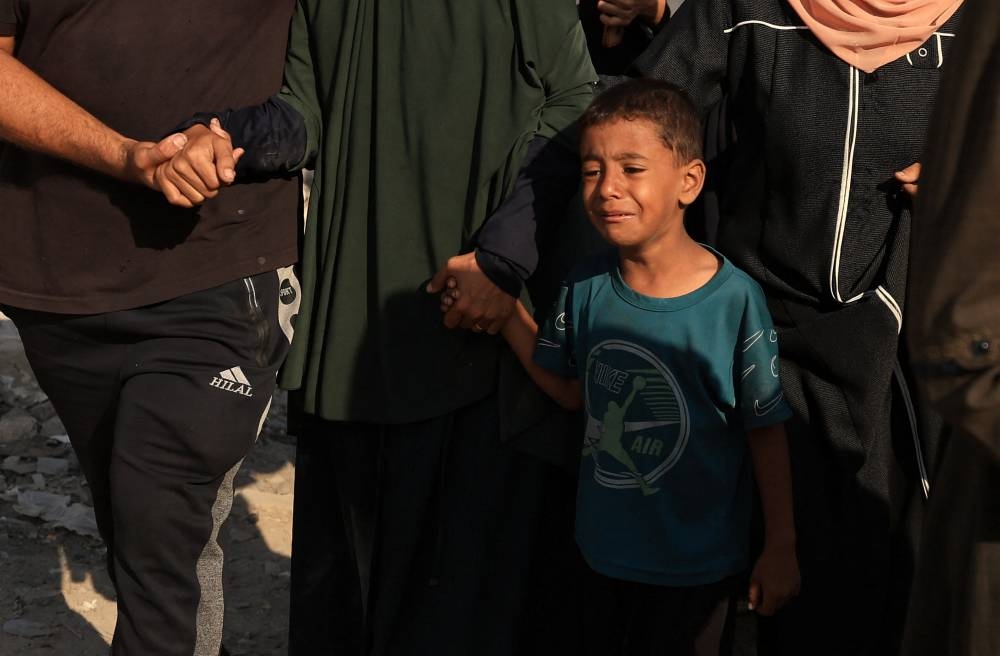 A boy reacts during the funeral of Palestinians killed in overnight Israeli strikes, according to medics, at Al-Shifa Hospital in Gaza City,yesterday.