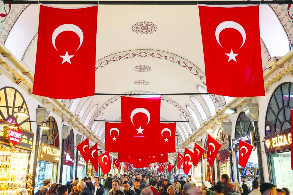People stroll through the historic Grand Bazaar, a popular tourist attraction and one of the country's most important economic venues, in Istanbul. The government’s new Medium-Term Program unveiled late Sunday sees the economy expanding 3.3% this year and 3.8% next, down from previous projections of 4% and 4.5%.