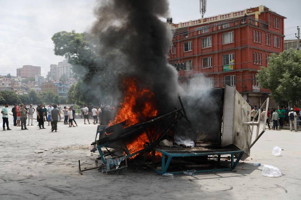 Items set on fire by protesters burn during a protest to condemn the police's deadly crackdown on demonstrators in Kathmandu on September 9, 2025, a day after demonstrations over social media prohibitions and corruption by the government. Nepal rolled back its social media ban on September 9, a day after at least 19 people were killed in youth protests demanding that the government lift its restrictions and tackle corruption. Protests continued on September 9, defying a curfew to vent anger at one of the deadliest crackdowns on demonstrators for years -- despite all major social media apps resuming operations online and the government appealing for calm. (AFP)