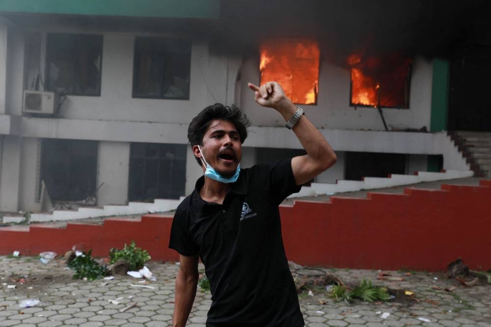 A demonstrator reacts outside the burning Nepali Congress Party office during a protest to condemn the police's deadly crackdown on demonstrators in Kathmandu on September 9, 2025 (AFP)