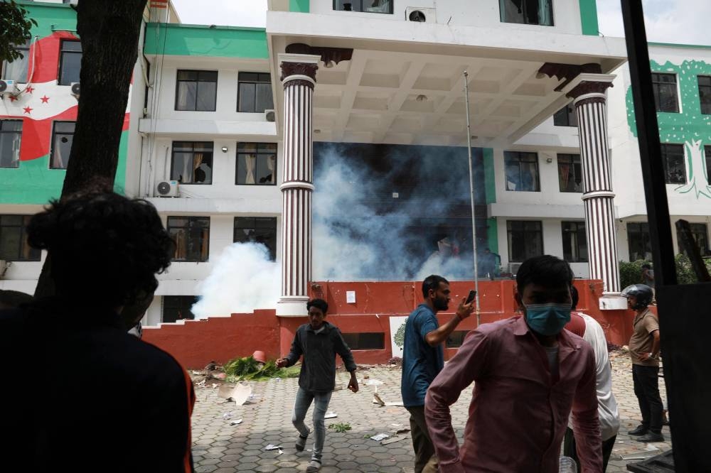 Demonstrators react outside the Nepali Congress Party office during a protest to condemn the police's deadly crackdown on demonstrators in Kathmandu on September 9, 2025 (AFP)