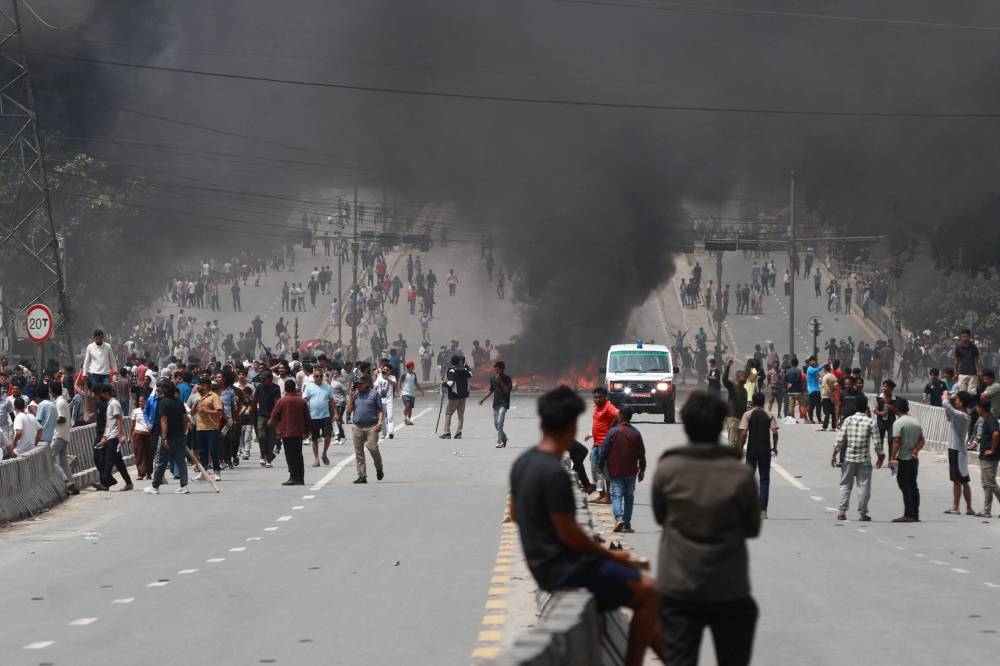 A fire burns as demonstrators gather on a road during a protest to condemn the police's deadly crackdown on demonstrators in Kathmandu on September 9, 2025 (AFP)