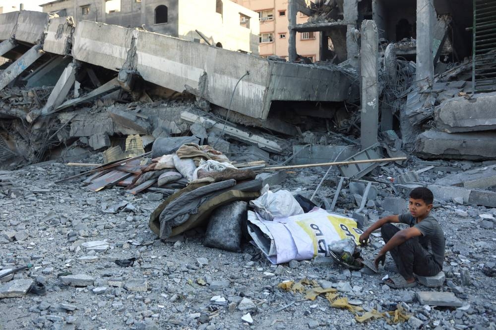 A Palestinians boy sits amidst the rubble of a school building destroyed in an Israeli strike in Gaza City the previous day, on September 10, 2025. (AFP)