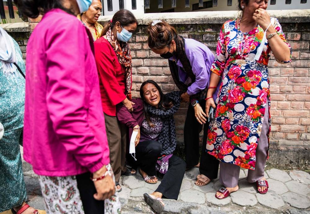 A family member (C) of a victim, who died during clashes with security personnel, mourns as she waits outside the Tribhuvan University Teaching Hospital to receive the victim's dead body amid ongoing unrest in Kathmandu, on Saturday. AFP
