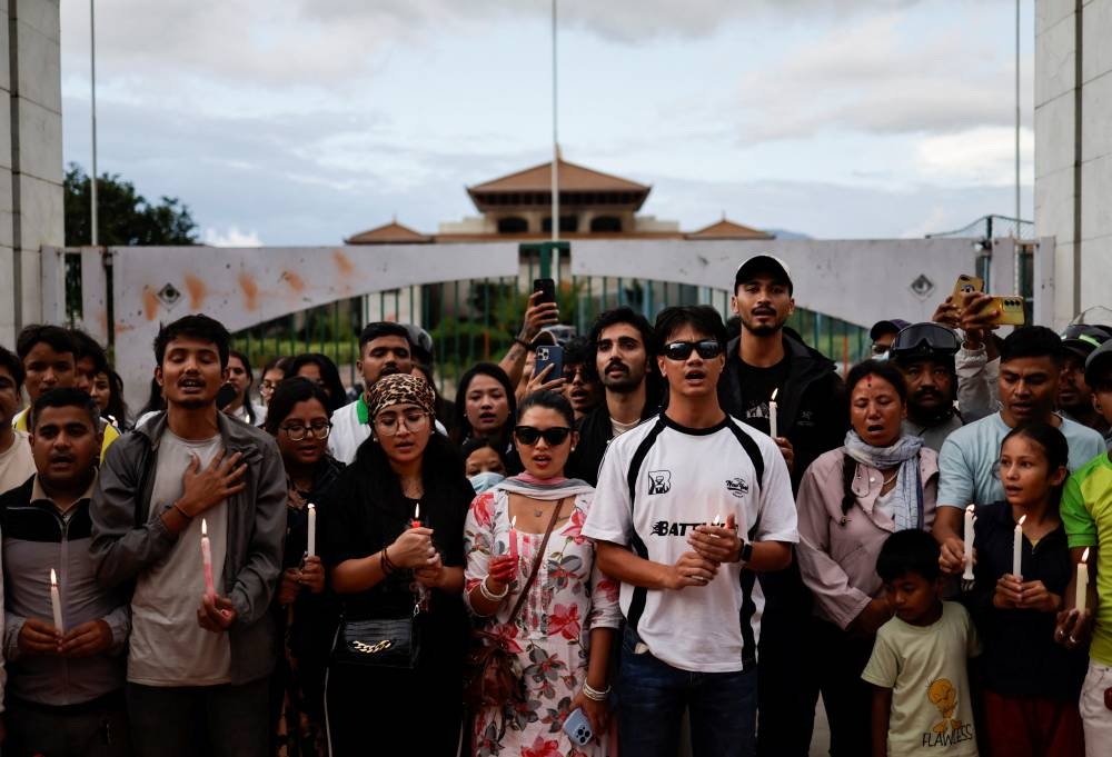 People holding lit candles sing the national anthem as they take part in a candlelight vigil in memory of people who died during the protest against anti-corruption triggered by a social media ban, which was later lifted, in Kathmandu, Nepal, on Saturday. REUTERS