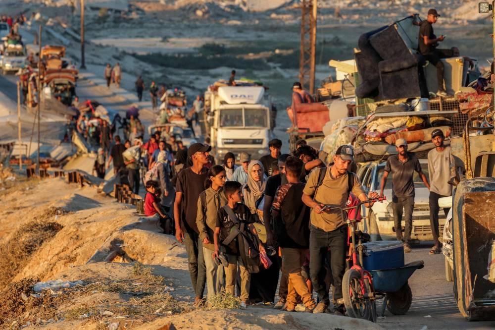 Displaced Palestinians evacuating southbound from Gaza City travel along the coastal road in Nuseirat in the central Gaza Strip Saturday.