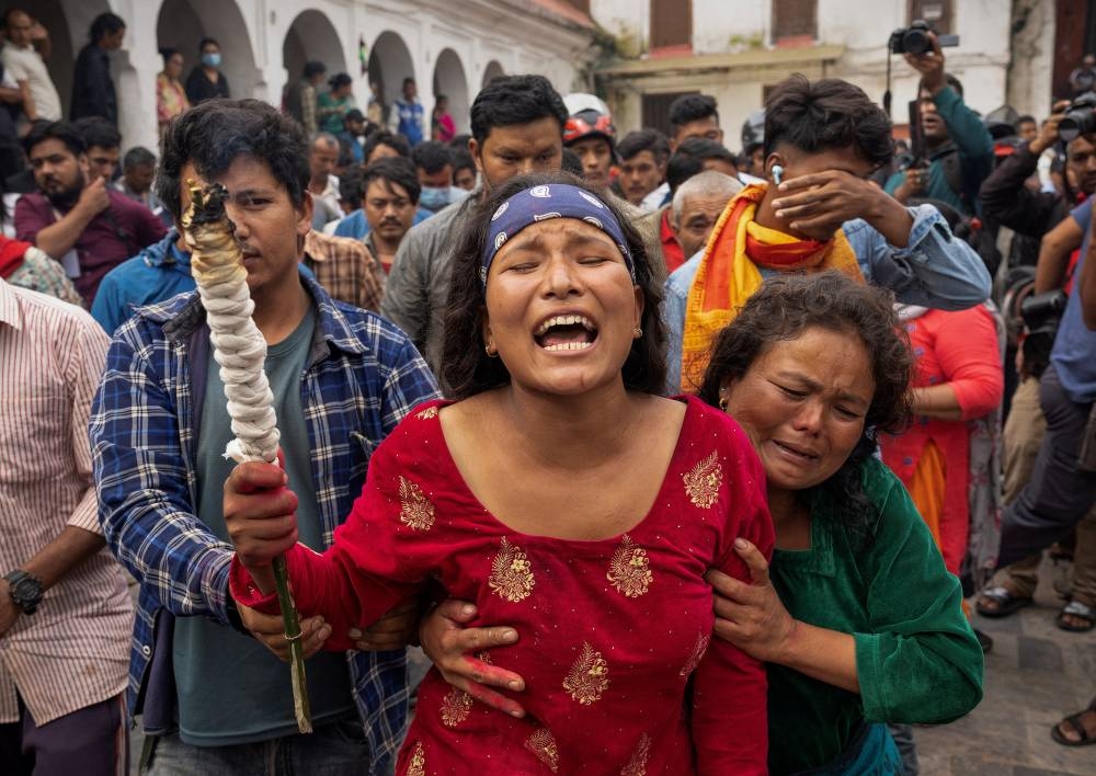 Sunita Balami, sister of Subhlal Balami, 28, who died in last week's anti-corruption protests, mourns as she performs last rituals during his cremation at the premises of Pashupatinath temple along the bank of Bagmati river in Kathmandu, Nepal, on Sunday. REUTERS