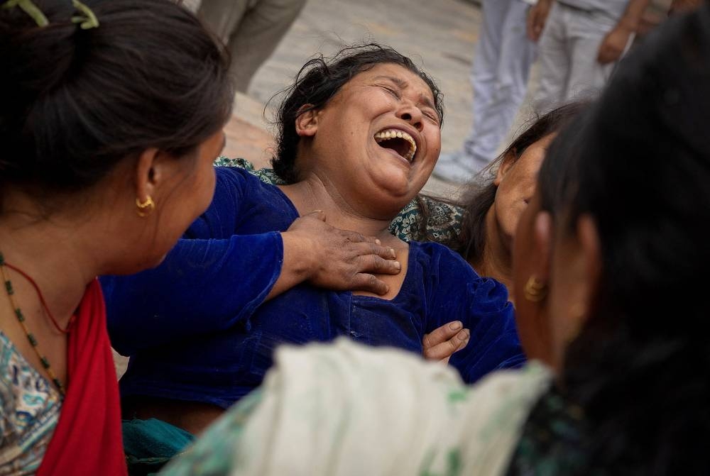 Bhagwati Balami, mother of Subhlal Balami, 28, who died in last week's anti-corruption protests, mourns during his cremation at the premises of Pashupatinath temple along the bank of Bagmati river in Kathmandu, Nepal, on Sunday. REUTERS