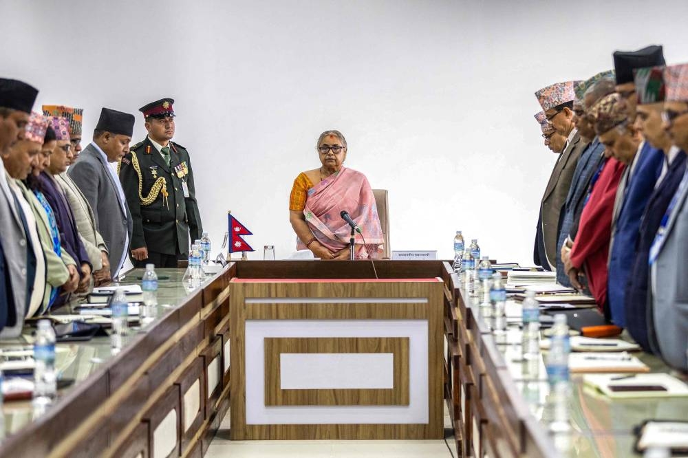 Newly-elected Prime Minister of Nepal's interim government Sushila Karki (C), along with officials, observes a moment of silence to pay her tribute to those who lost their lives in recent protests in Kathmandu, on Sunday. AFP