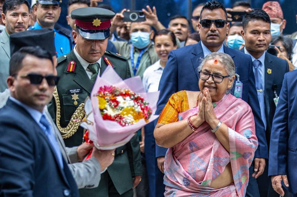 Officials greet newly-elected Prime Minister of Nepal's interim government Sushila Karki (R) as she arrives at her office in Kathmandu, on Sunday. AFP