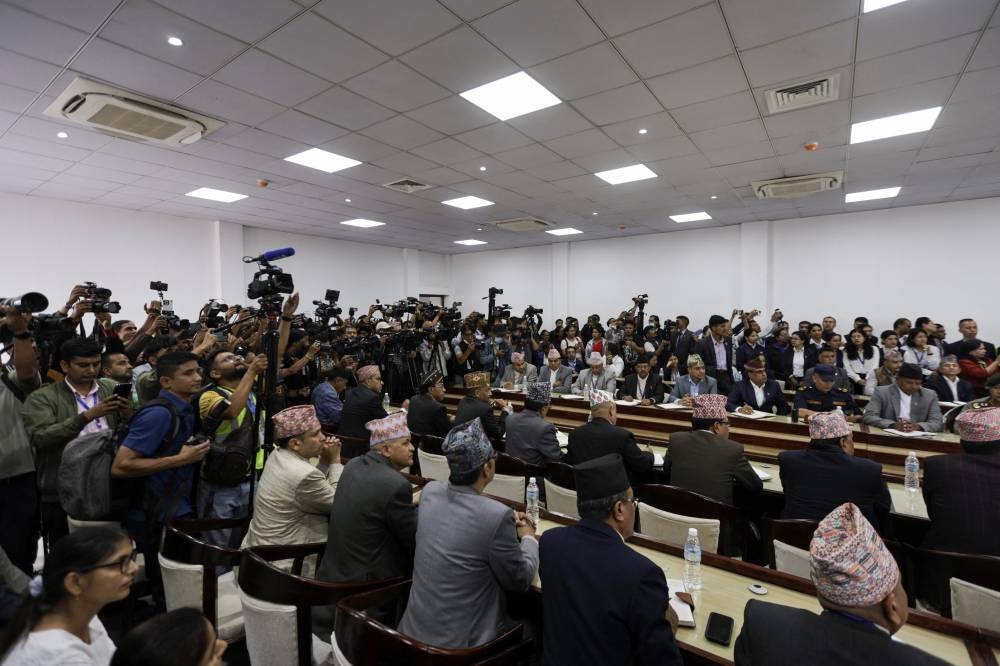 Journalists cover the meeting of newly sworn-in interim Prime Minister of Nepal, Sushila Karki, after she assumes the post in her office at Singha Durbar office complex that houses the Prime Minister's office and other ministries, on Sunday. REUTERS